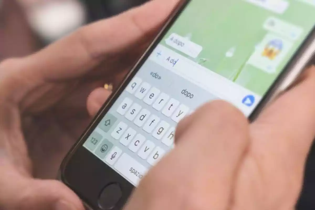 Persona escribiendo un mensaje en un teléfono móvil.