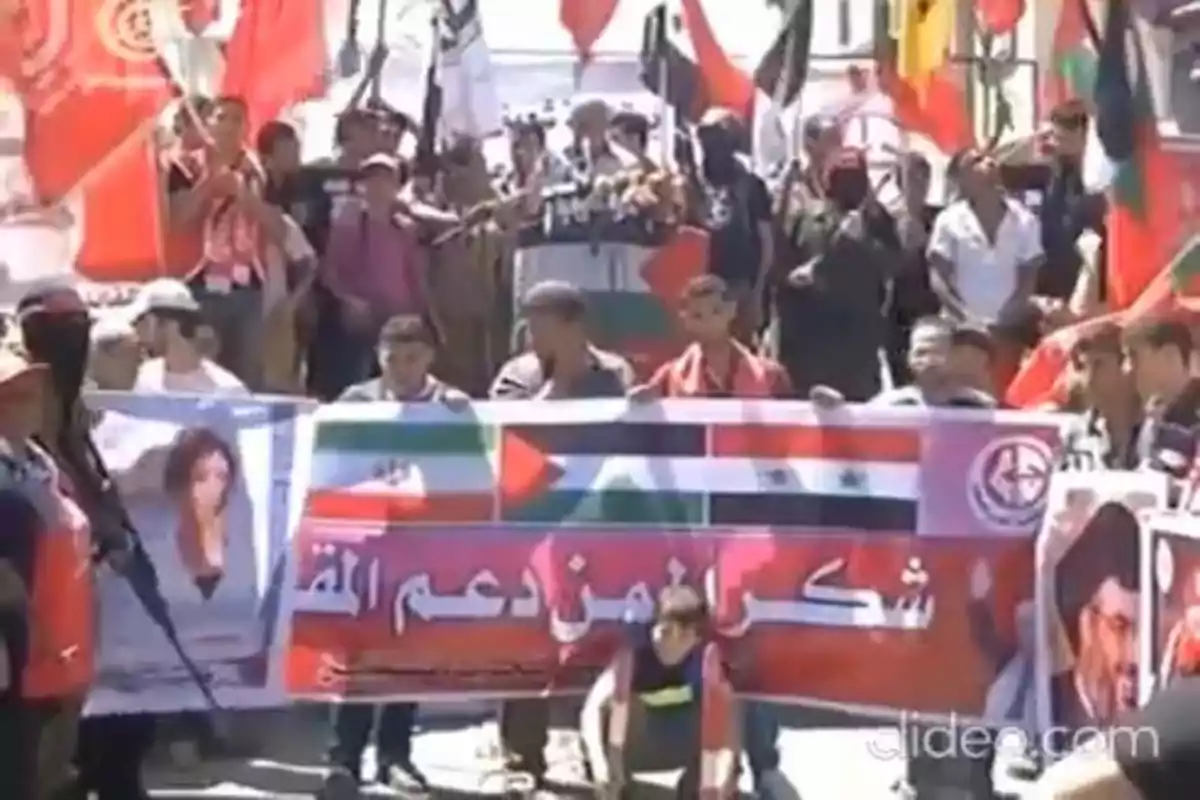 Manifestación con personas sosteniendo pancartas y banderas de varios países de Medio Oriente Manifestación con personas sosteniendo pancartas y banderas de varios países de Medio Oriente