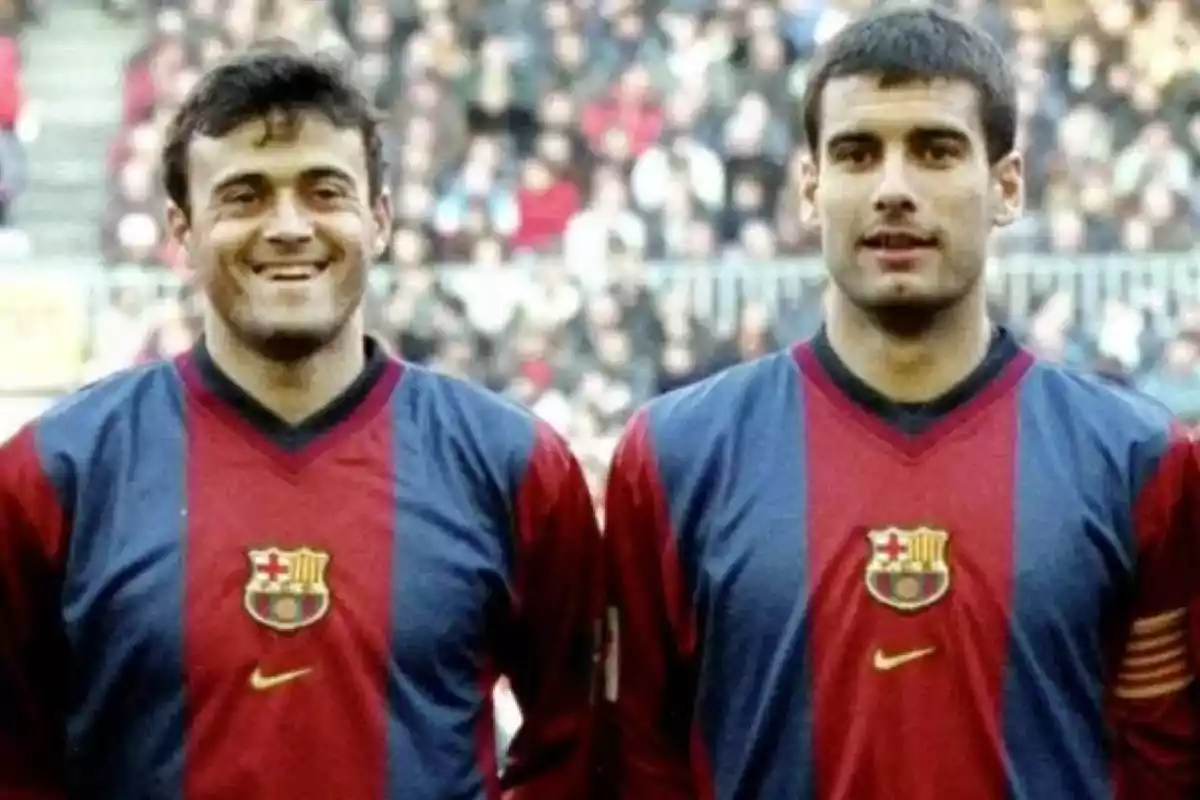 Dos futbolistas con uniforme del FC Barcelona posan en el campo con el público de fondo Dos futbolistas con uniforme del FC Barcelona posan en el campo con el público de fondo