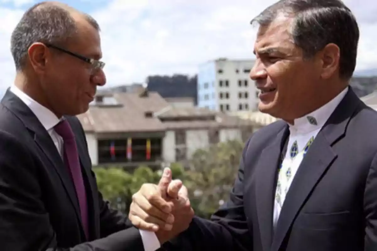 Dos hombres de traje estrechándose la mano al aire libre con edificios de fondo.