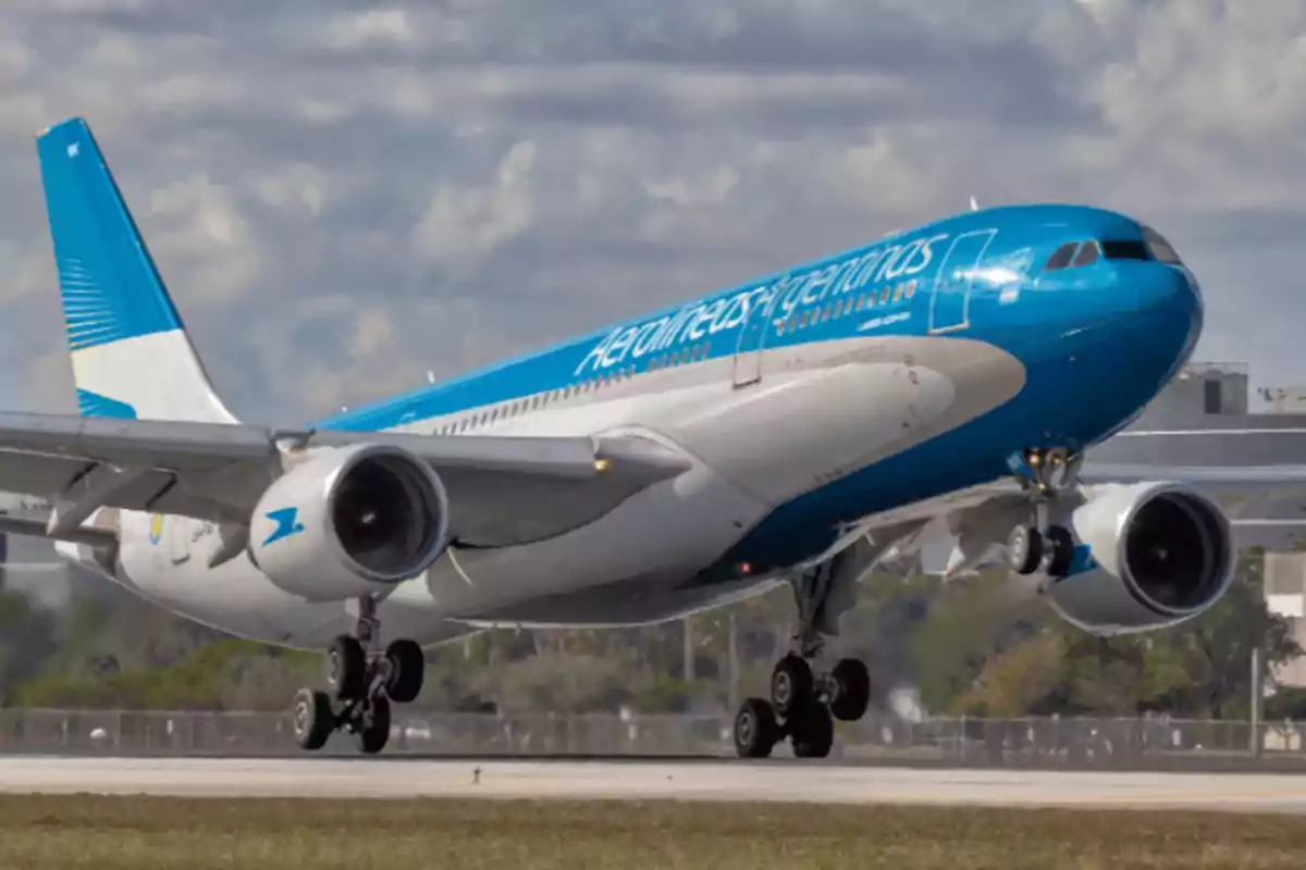 Un avión de Aerolíneas Argentinas despegando de una pista de aterrizaje.