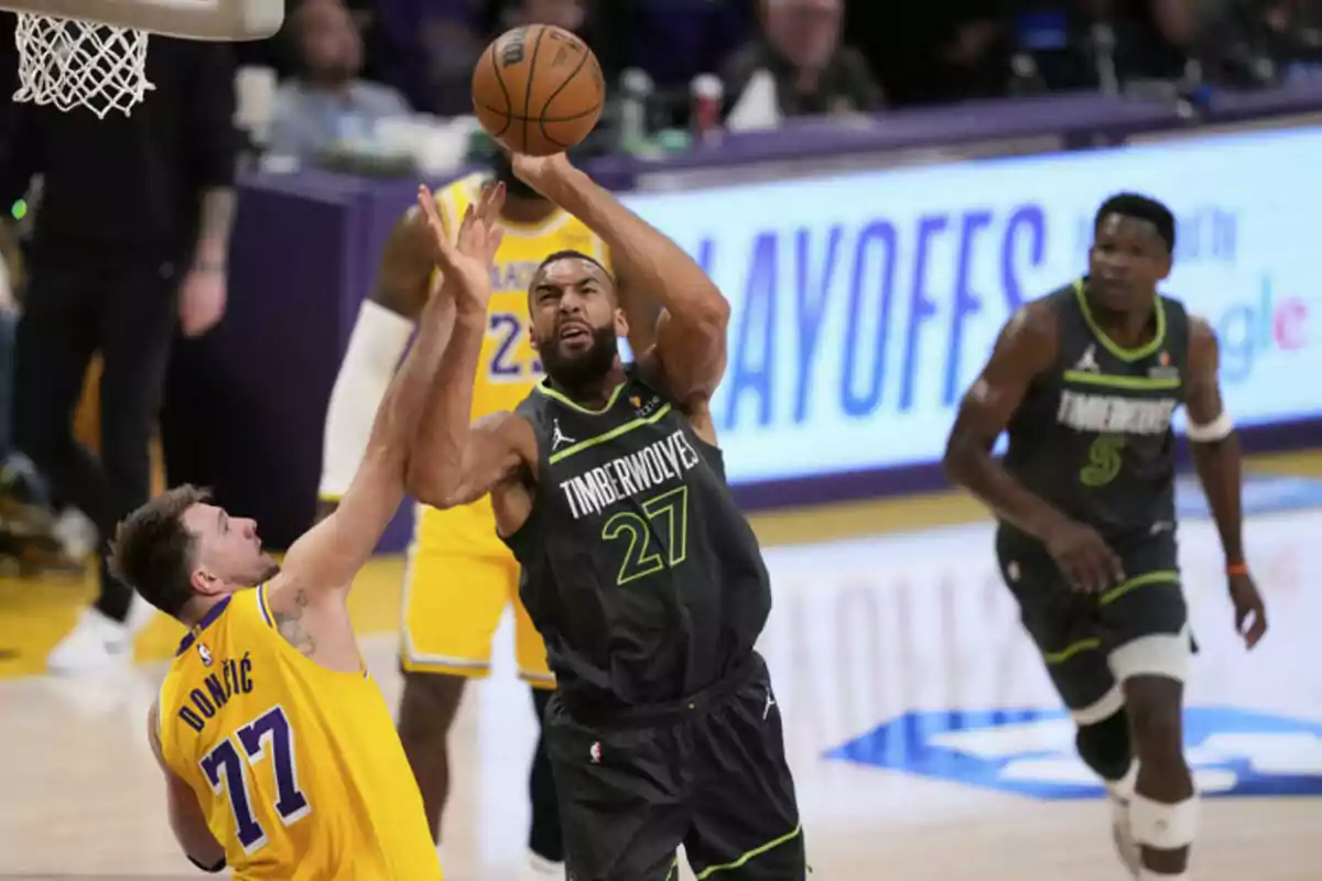 Basketball players in action during a play-off game, one of them attempts to block a shot while another gets ready to shoot. Basketball players in action during a play-off game, one of them attempts to block a shot while another gets ready to shoot.