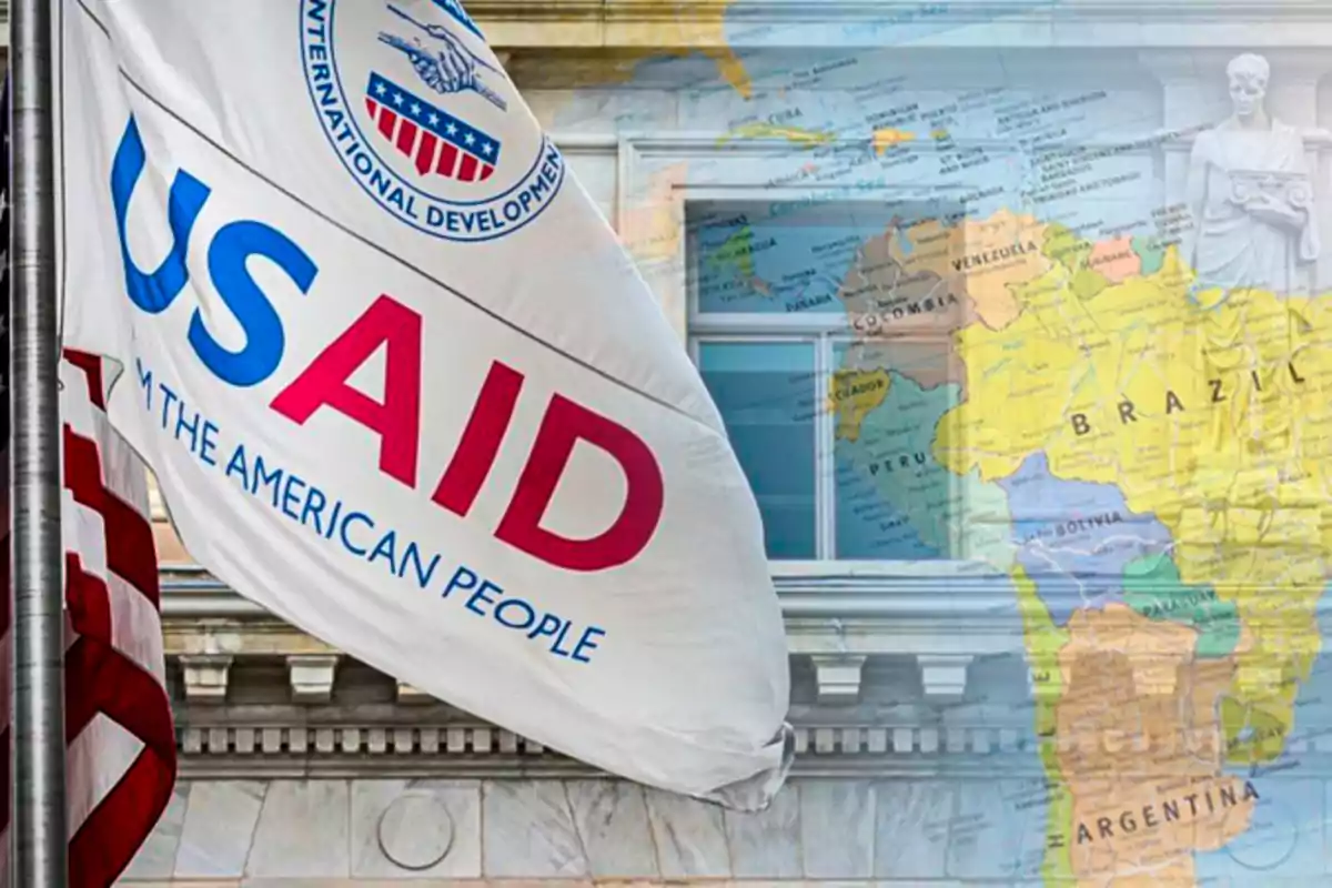 Una bandera de USAID ondea frente a un edificio, con un mapa de América del Sur superpuesto en el fondo.