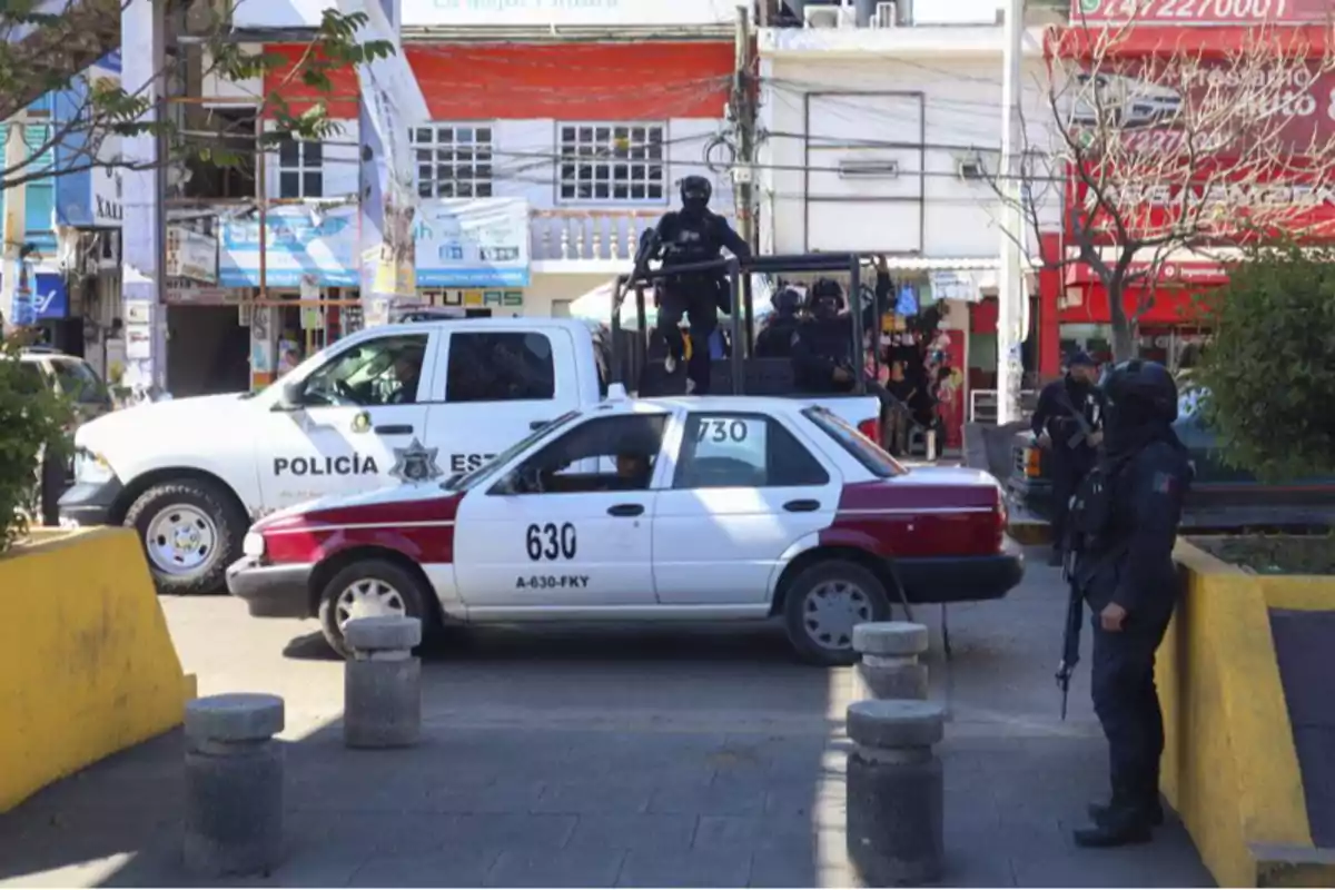 Una escena urbana muestra un vehículo de la policía estatal y un taxi en una intersección, con varios agentes de policía armados alrededor.