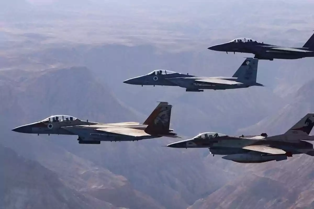 Cuatro aviones de combate vuelan en formación sobre un paisaje montañoso árido Cuatro aviones de combate vuelan en formación sobre un paisaje montañoso árido