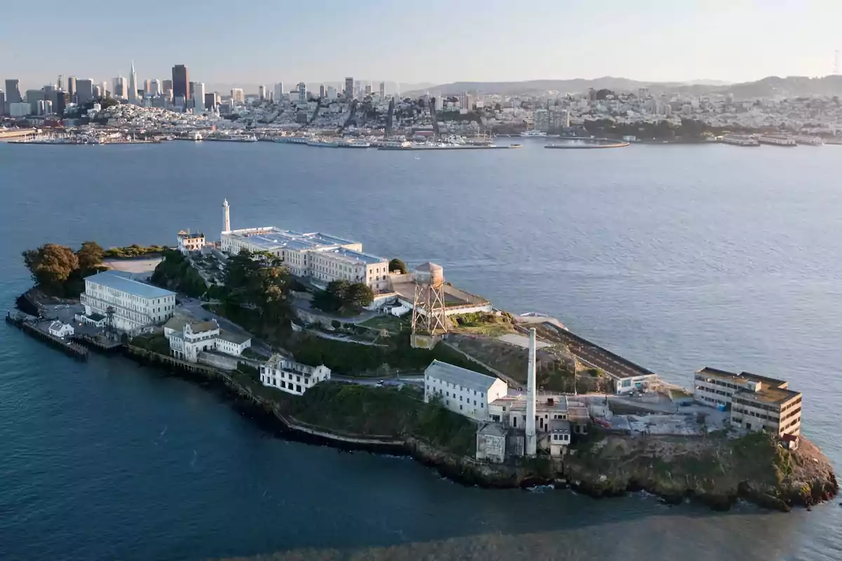 Aerial view of an island with historic buildings surrounded by water, with a city in the background. Aerial view of an island with historic buildings surrounded by water, with a city in the background.