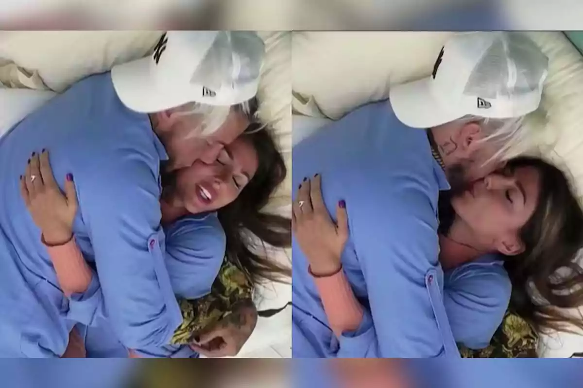 Dos personas abrazándose y besándose en una cama, ambos visten ropa azul y una de ellas lleva una gorra blanca. Dos personas abrazándose y besándose en una cama, ambos visten ropa azul y una de ellas lleva una gorra blanca.