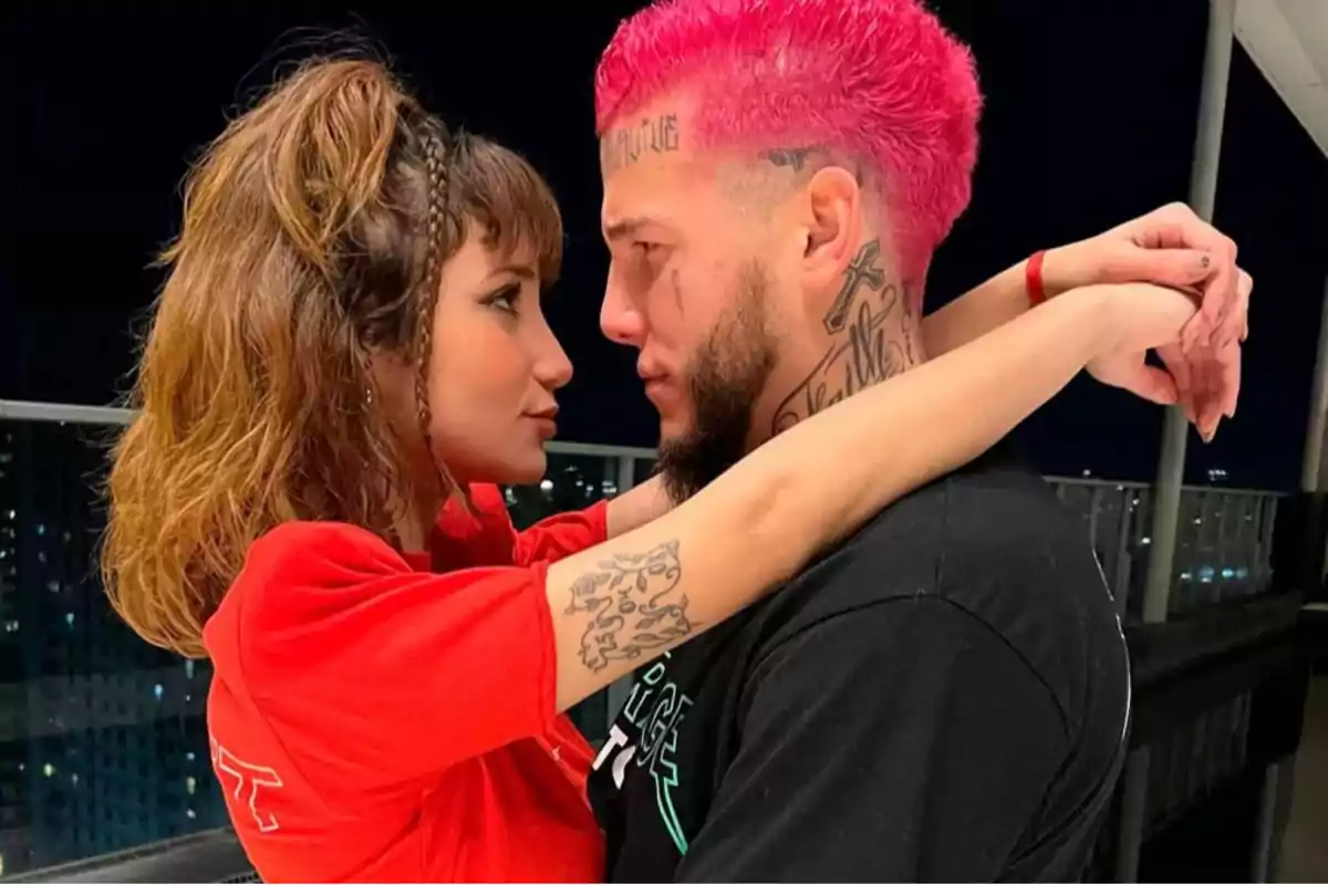 Dos personas mirándose a los ojos con ternura en un balcón por la noche. Dos personas mirándose a los ojos con ternura en un balcón por la noche.