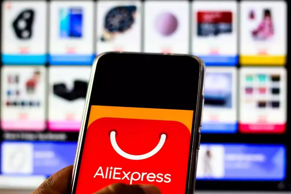Person holding a mobile phone displaying the AliExpress logo with a blurred product screen in the background Person holding a mobile phone displaying the AliExpress logo with a blurred product screen in the background