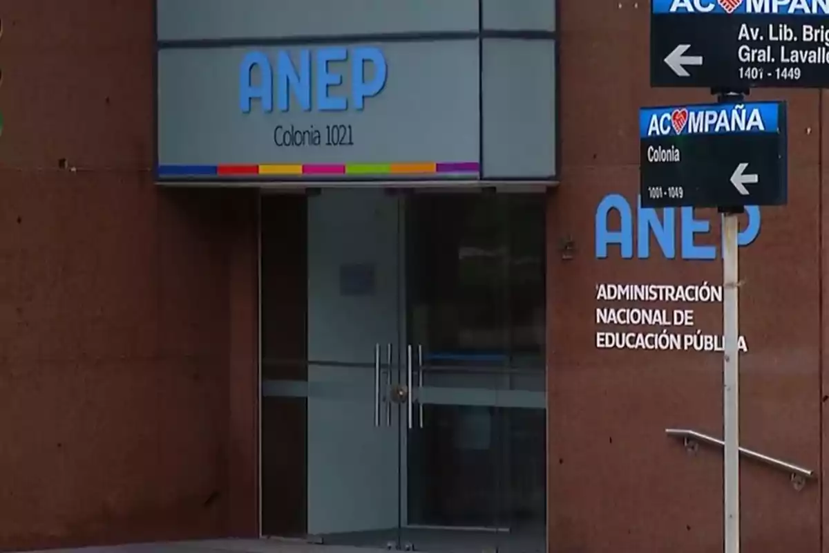 Entrada de un edificio de la Administración Nacional de Educación Pública con letreros de dirección en la calle. Entrada de un edificio de la Administración Nacional de Educación Pública con letreros de dirección en la calle.