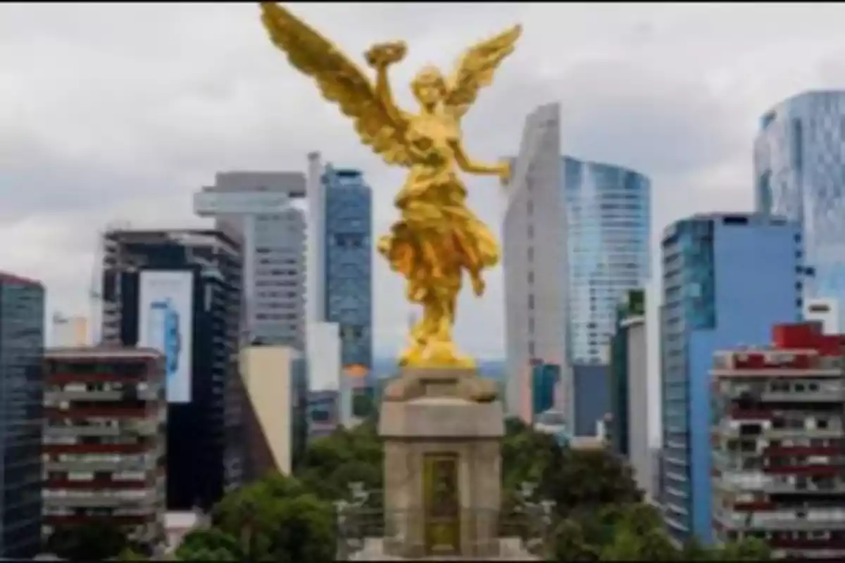 Monumento del Ángel de la Independencia en la Ciudad de México con edificios modernos al fondo.