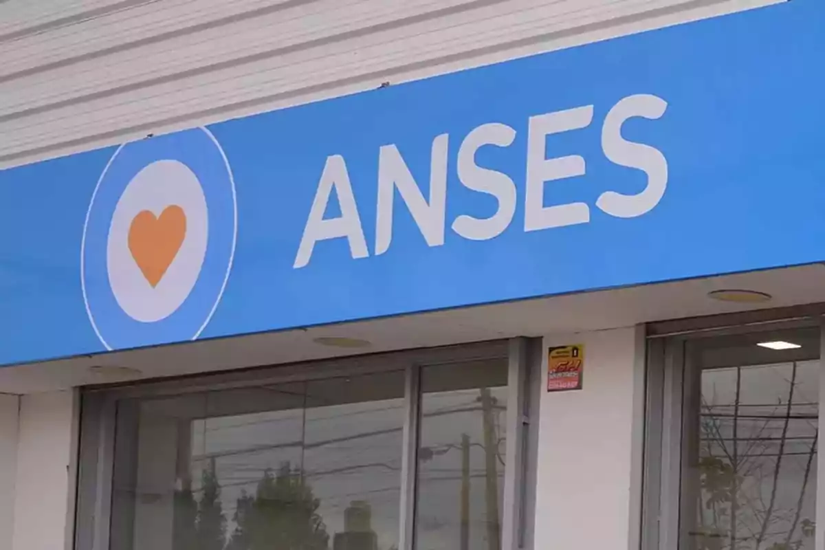 Fachada de una oficina de ANSES con un cartel azul y un corazón naranja.