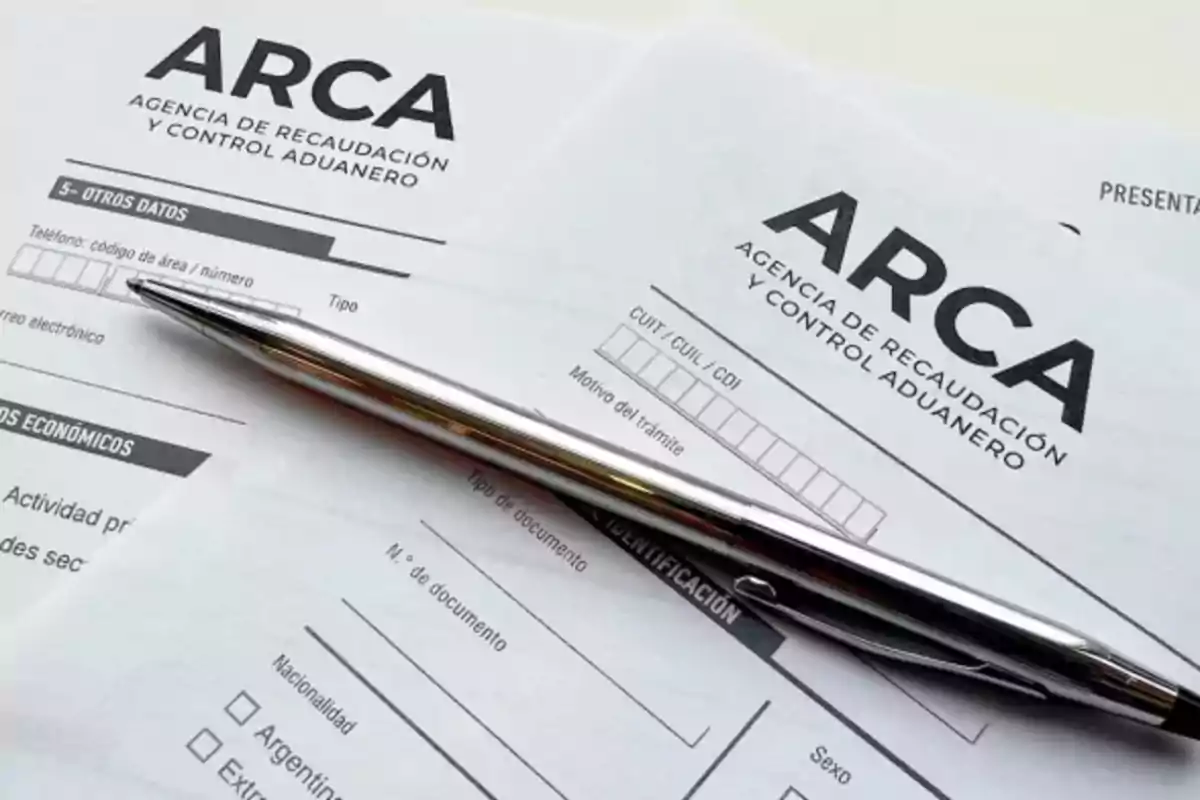 Forms from the Revenue and Customs Control Agency with a silver pen on top Forms from the Revenue and Customs Control Agency with a silver pen on top