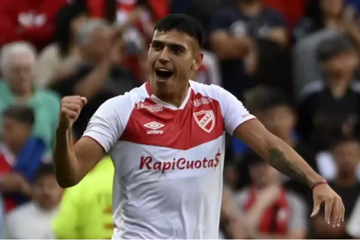 Jugador de fútbol celebrando un gol con la camiseta de un equipo con colores rojo y blanco. Jugador de fútbol celebrando un gol con la camiseta de un equipo con colores rojo y blanco.