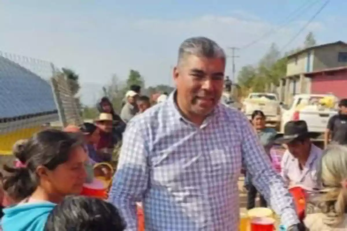 Hombre de camisa a cuadros repartiendo bebidas a personas en una comunidad rural Hombre de camisa a cuadros repartiendo bebidas a personas en una comunidad rural