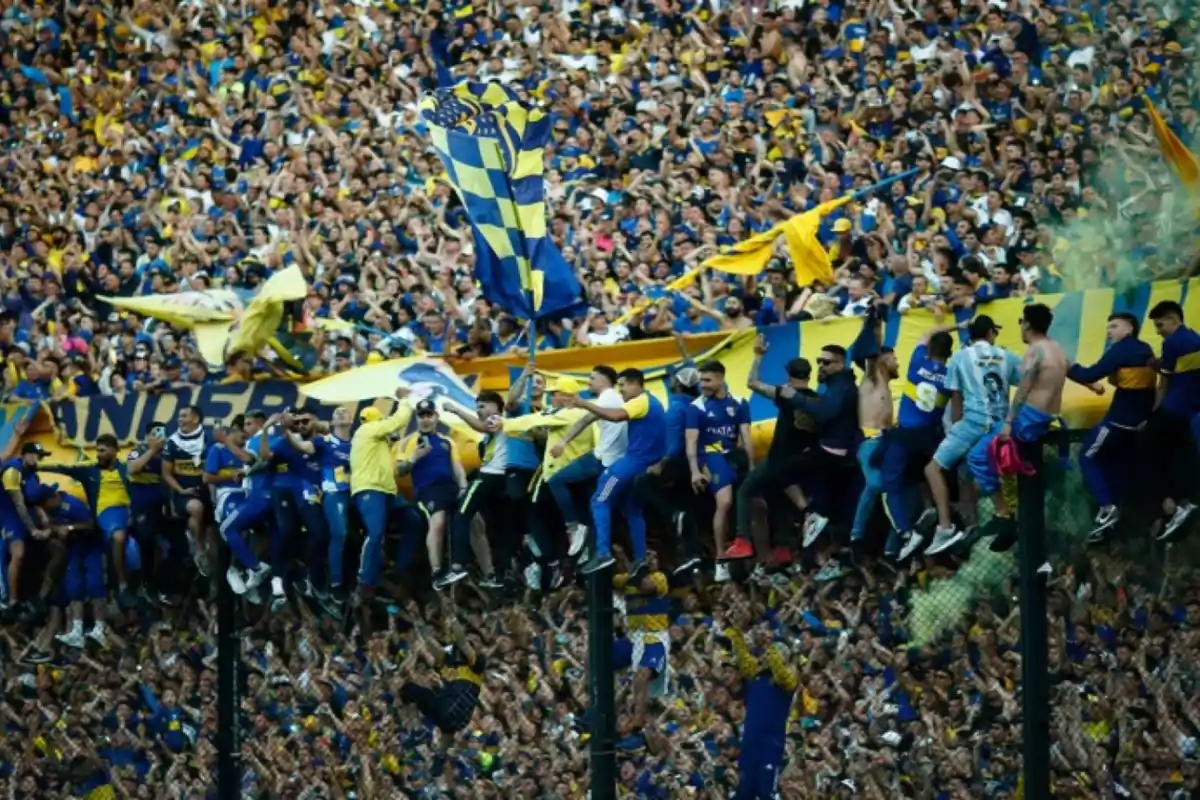 Aficionados de fútbol celebrando en las gradas con banderas y camisetas en un estadio lleno de gente. Aficionados de fútbol celebrando en las gradas con banderas y camisetas en un estadio lleno de gente.