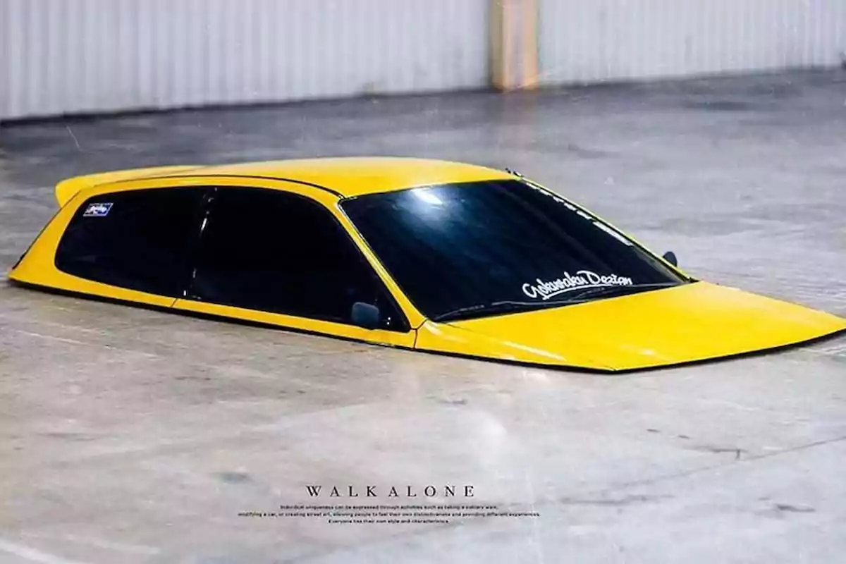 A yellow car appears to be sunk into the ground of a parking lot, with only the roof and windows visible. A yellow car appears to be sunk into the ground of a parking lot, with only the roof and windows visible.