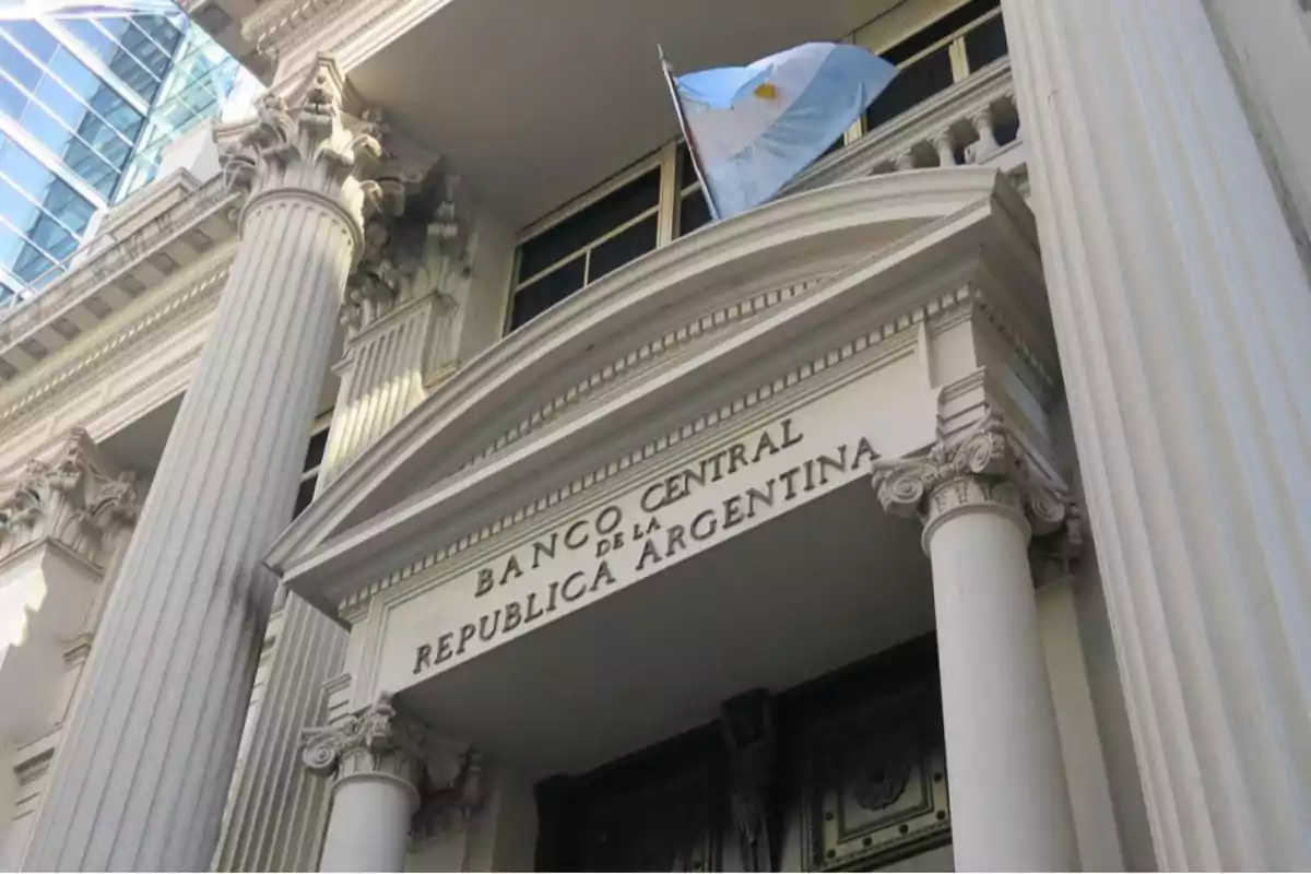 Fachada del Banco Central de la República Argentina con columnas clásicas y una bandera argentina ondeando.