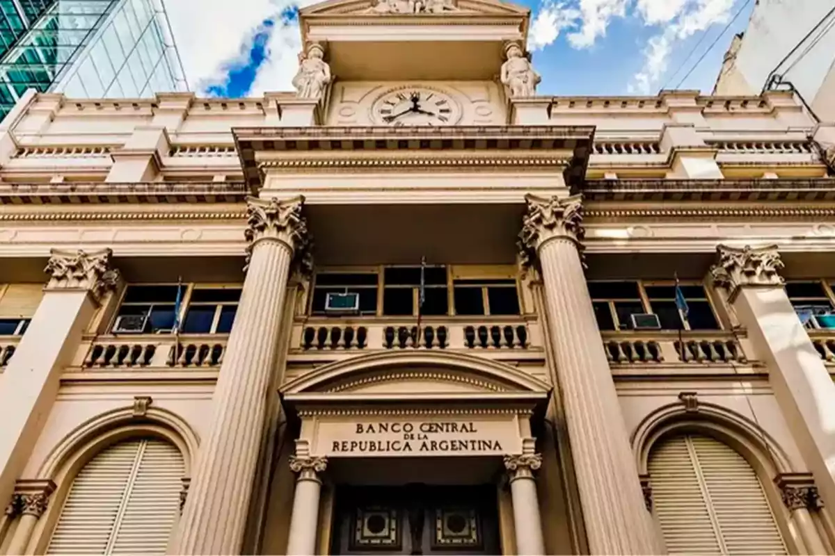Fachada del edificio del Banco Central de la República Argentina con columnas y un reloj en la parte superior bajo un cielo parcialmente nublado