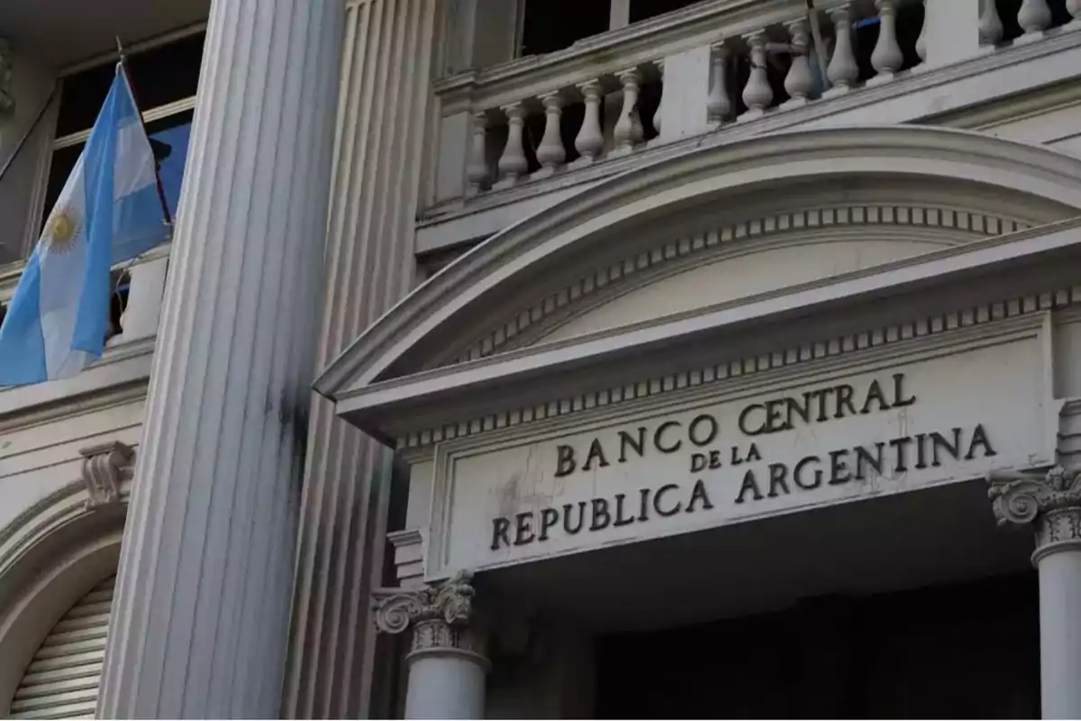 Fachada del Banco Central de la República Argentina con una bandera argentina ondeando.