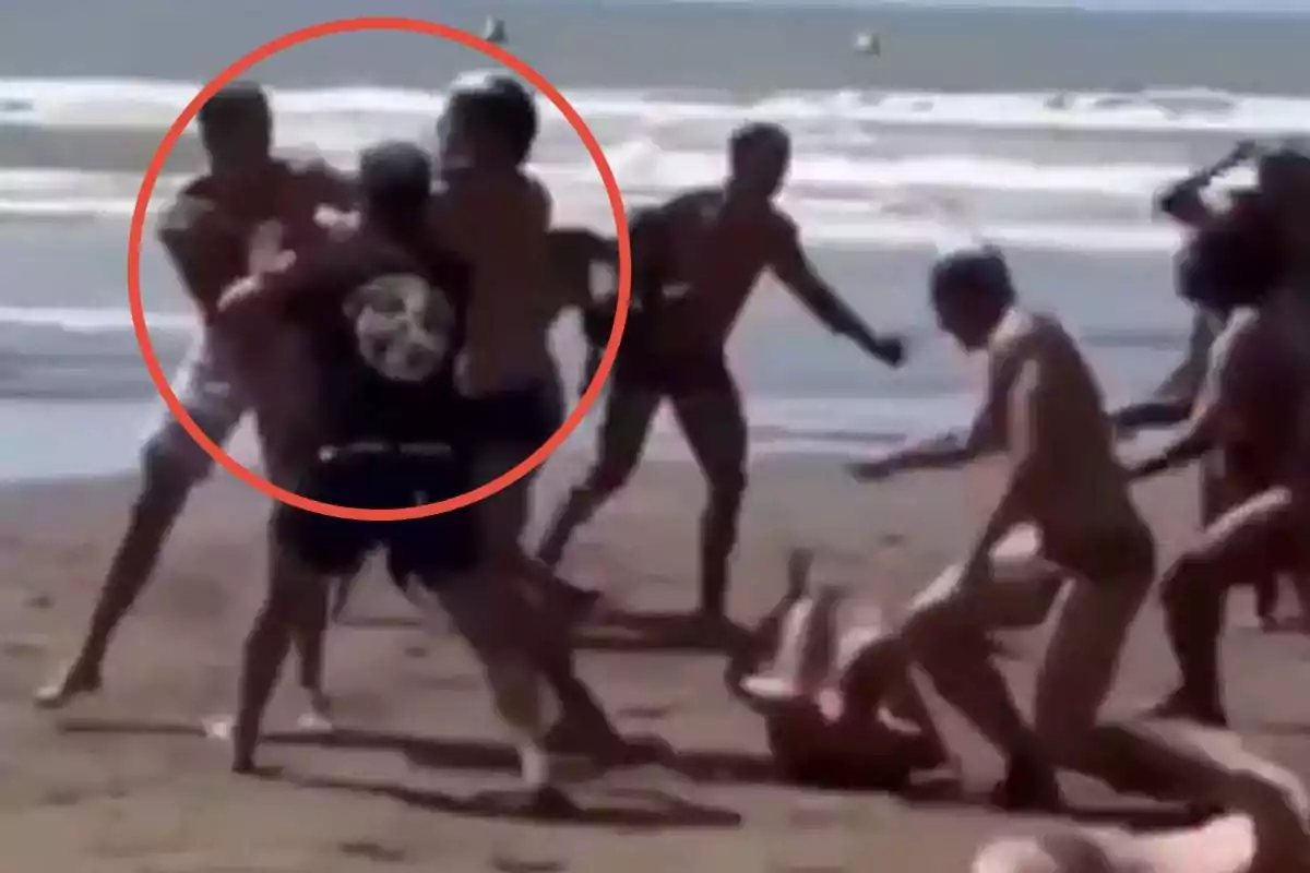 Un grupo de personas en la playa parece estar involucrado en una confrontación física.