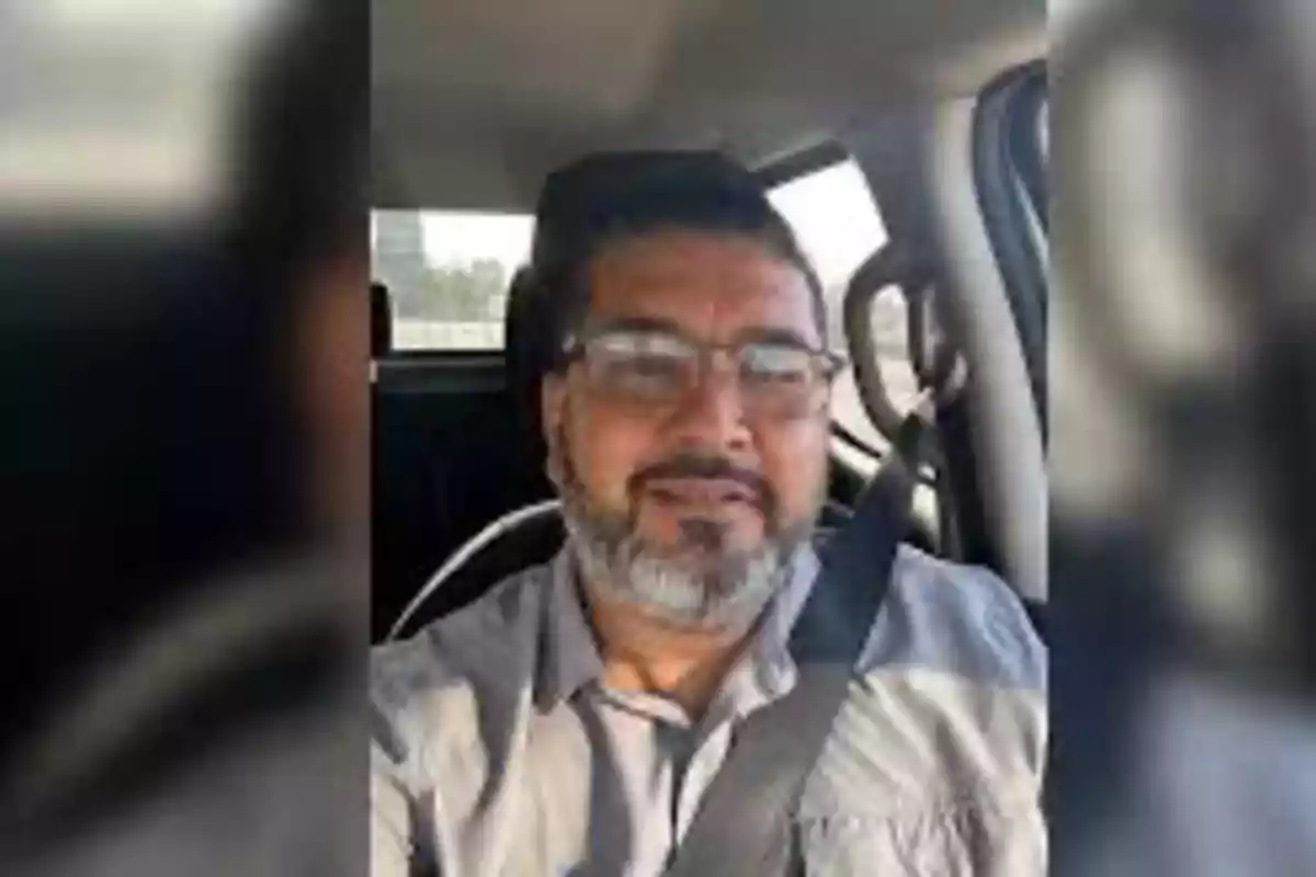 Man with a beard and glasses driving a car. Man with a beard and glasses driving a car.