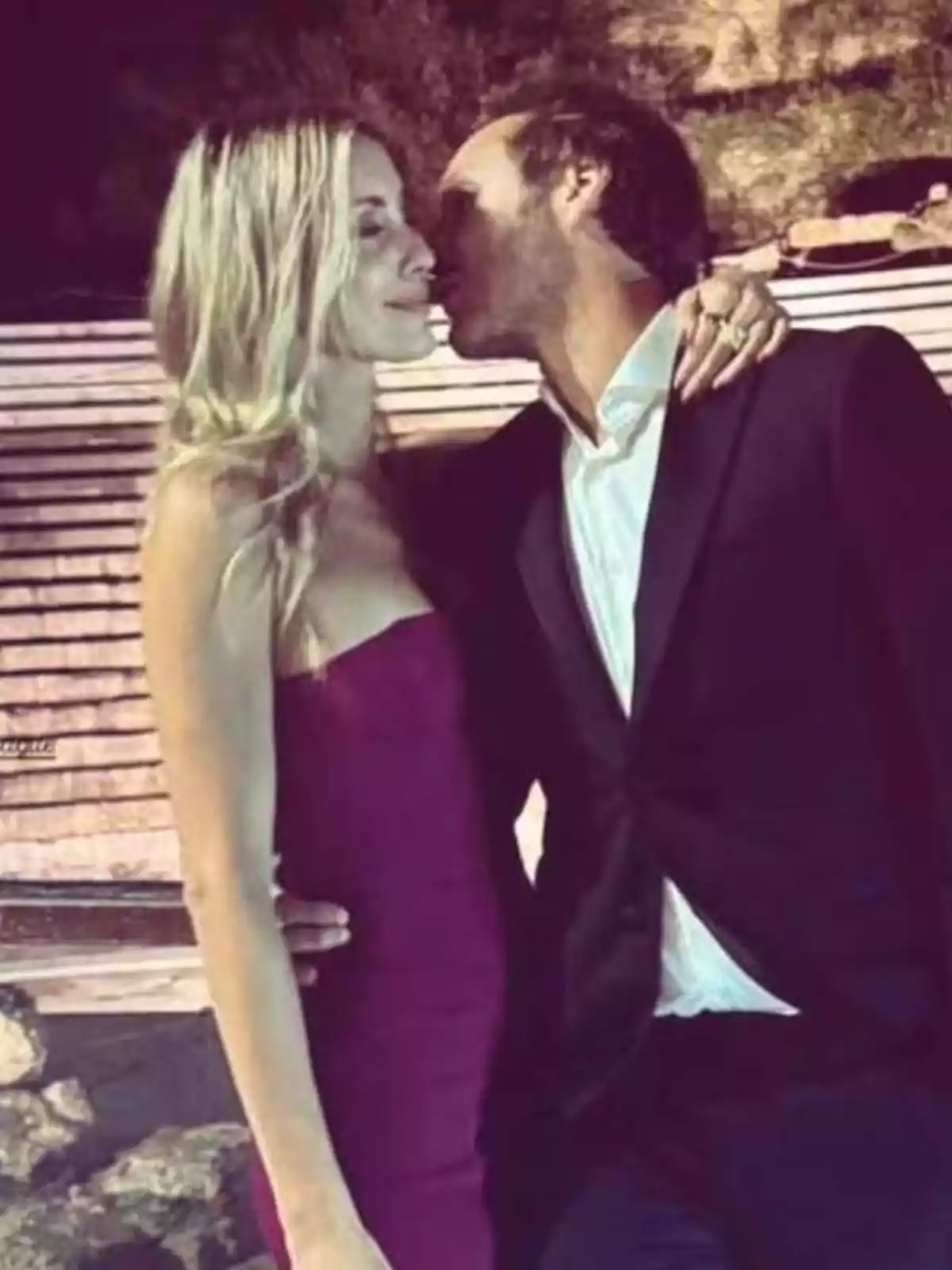 A smartly dressed couple shares a romantic moment outdoors. A smartly dressed couple shares a romantic moment outdoors.