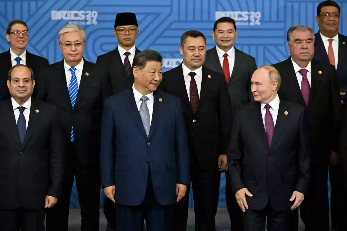 Un grupo de líderes mundiales posando juntos en un evento con fondo azul que muestra el logo de BRICS 2024.