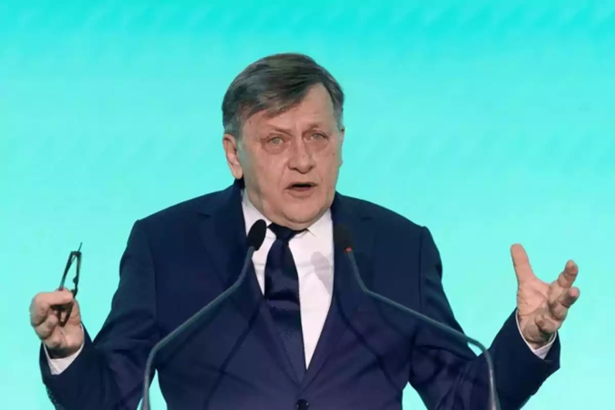 Hombre de traje hablando en un podio con fondo azul. Hombre de traje hablando en un podio con fondo azul.