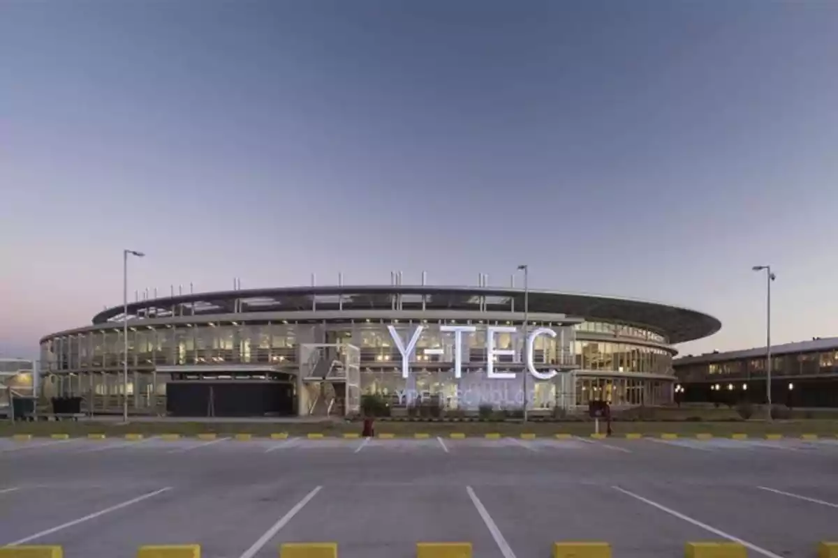 Modern Y-TEC building with illuminated facade at sunset. Modern Y-TEC building with illuminated facade at sunset.