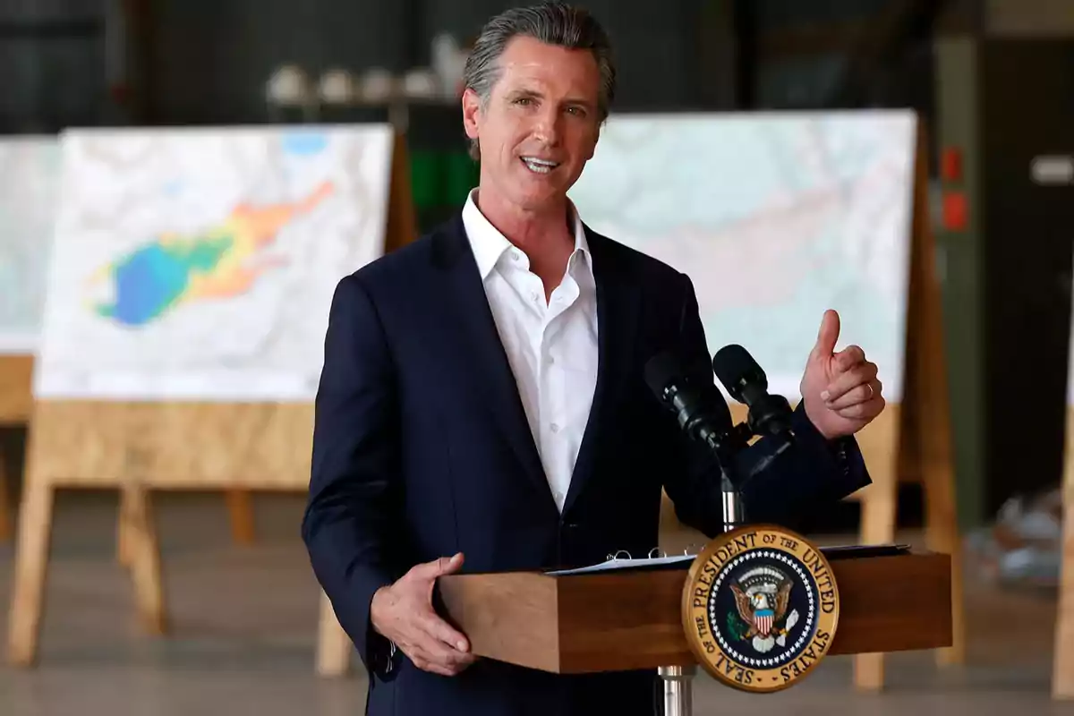 Un hombre de traje oscuro y camisa blanca habla en un podio con el sello presidencial de Estados Unidos, con mapas en el fondo.