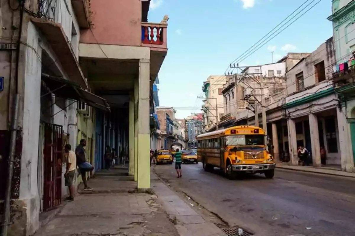 An urban street with old buildings and a yellow bus driving by. An urban street with old buildings and a yellow bus driving by.