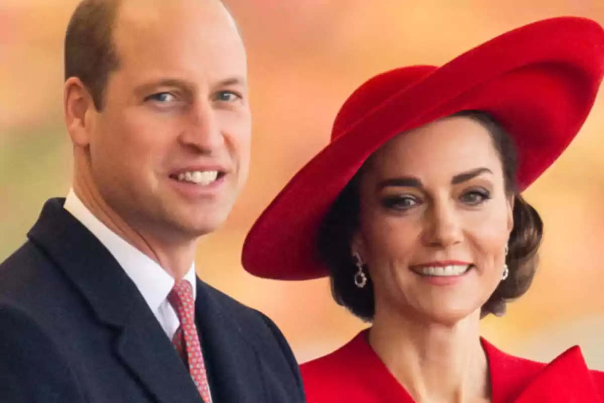 Dos personas sonrientes, una de ellas lleva un sombrero rojo.