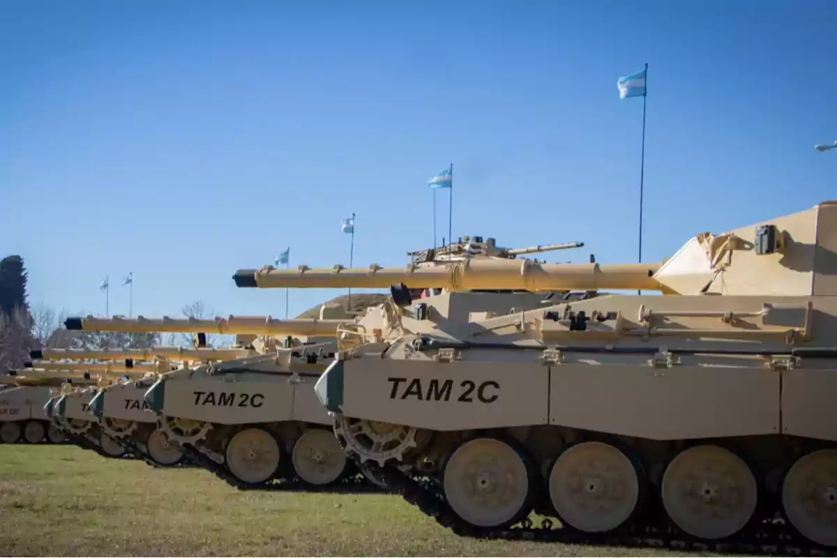 Fila de tanques TAM 2C en un campo con banderas argentinas ondeando.