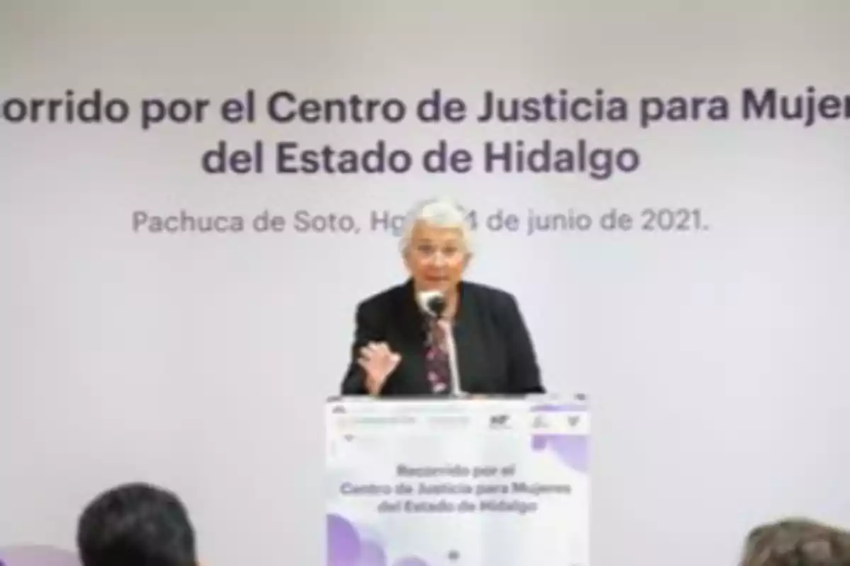 Una persona hablando en un podio durante un evento en el Centro de Justicia para Mujeres del Estado de Hidalgo.