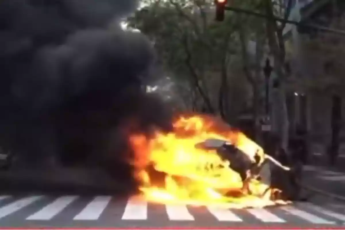 Una escena de un incendio en la calle con humo negro y llamas intensas.