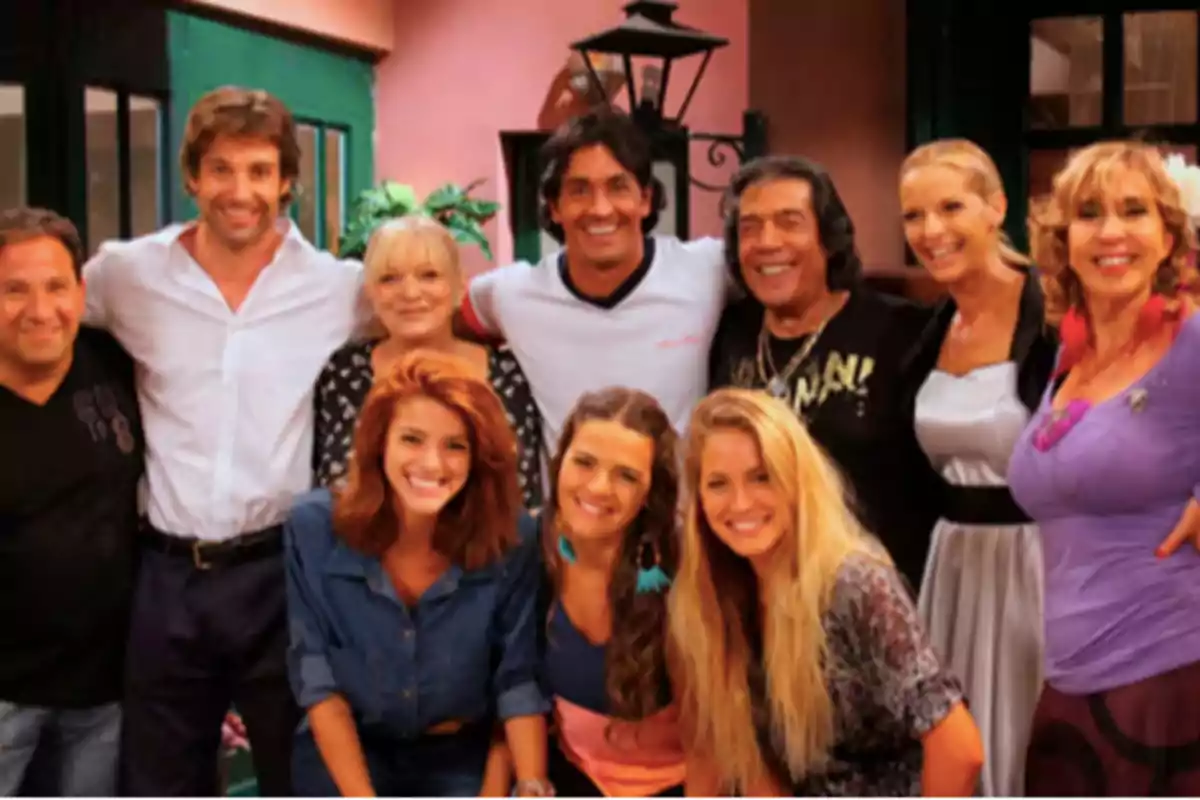 A group of people smiles while posing together in a colorful indoor setting. A group of people smiles while posing together in a colorful indoor setting.