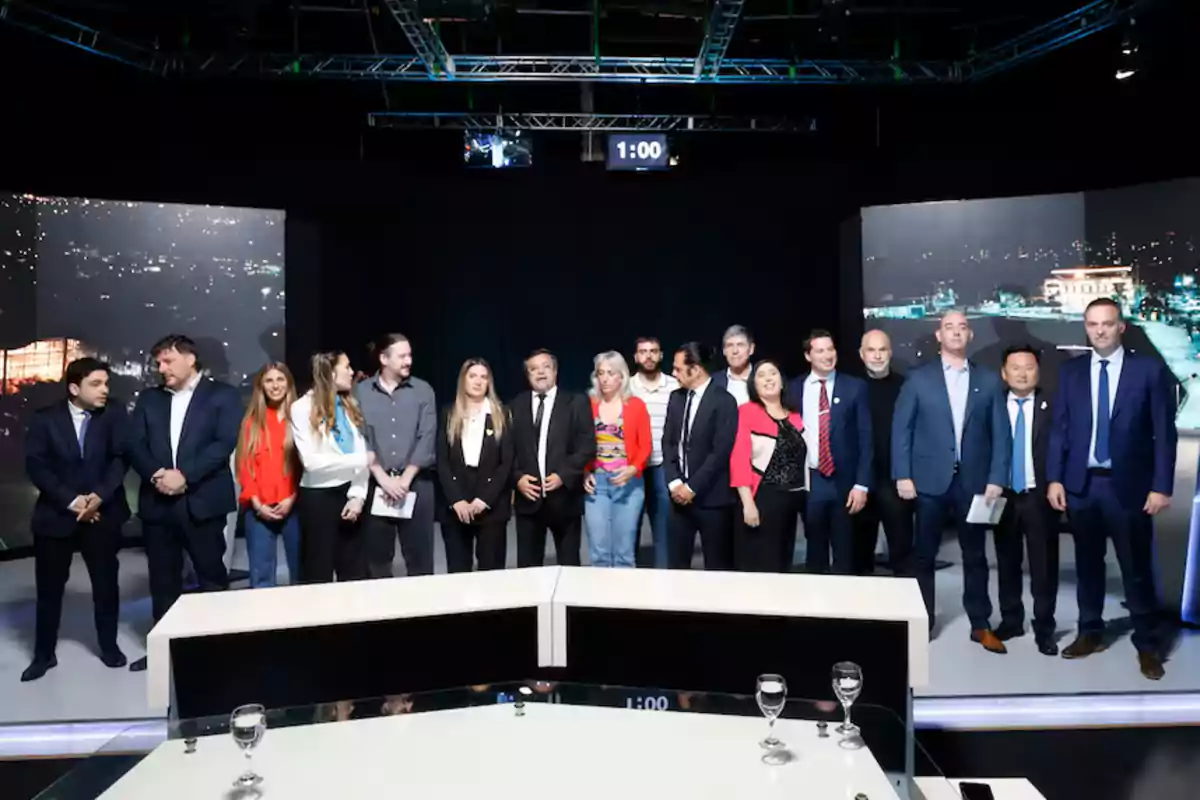 A group of people posing together on a stage with screens in the background and a digital timer above them. A group of people posing together on a stage with screens in the background and a digital timer above them.