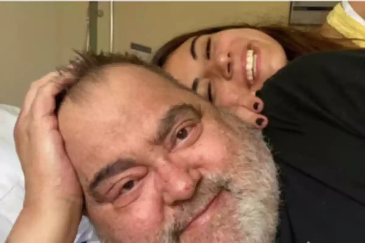 Un hombre con barba y una mujer sonriente detrás de él. Un hombre con barba y una mujer sonriente detrás de él.