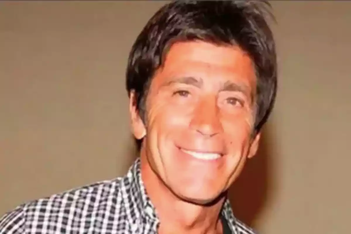 A smiling man in a plaid jersey.