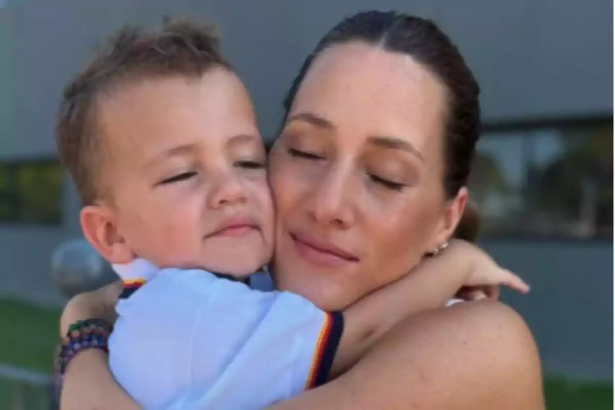 A woman and a child embrace with their eyes closed, showing an expression of tenderness and love. A woman and a child embrace with their eyes closed, showing an expression of tenderness and love.