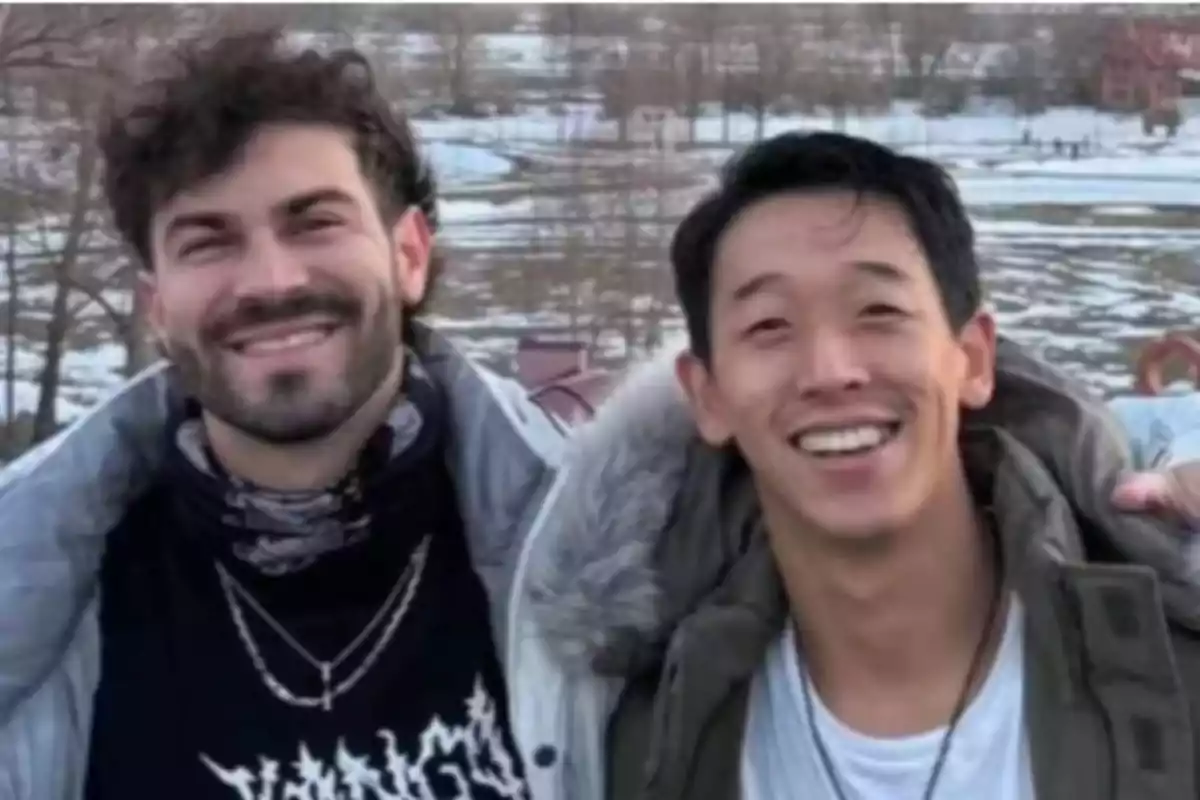 Dos personas sonrientes posan juntas al aire libre en un entorno invernal. Dos personas sonrientes posan juntas al aire libre en un entorno invernal.