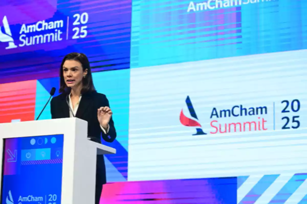 A person speaking at a podium during the AmCham Summit 2025.