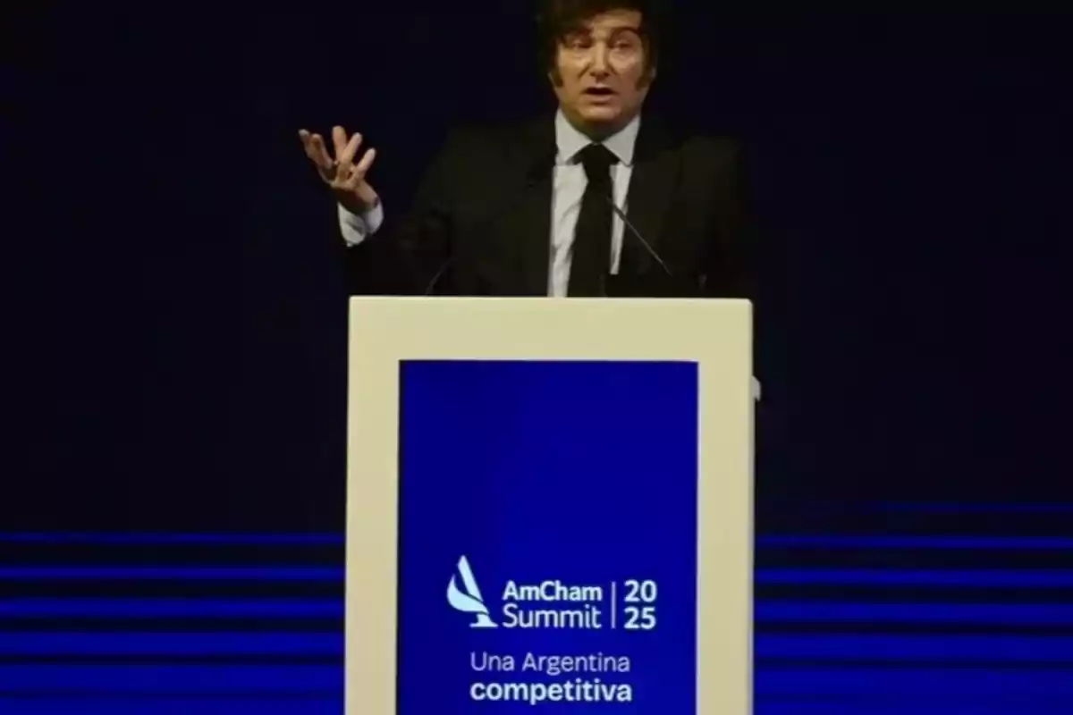 Un hombre de traje hablando en un podio durante el AmCham Summit 2025 con el lema Un hombre de traje hablando en un podio durante el AmCham Summit 2025 con el lema