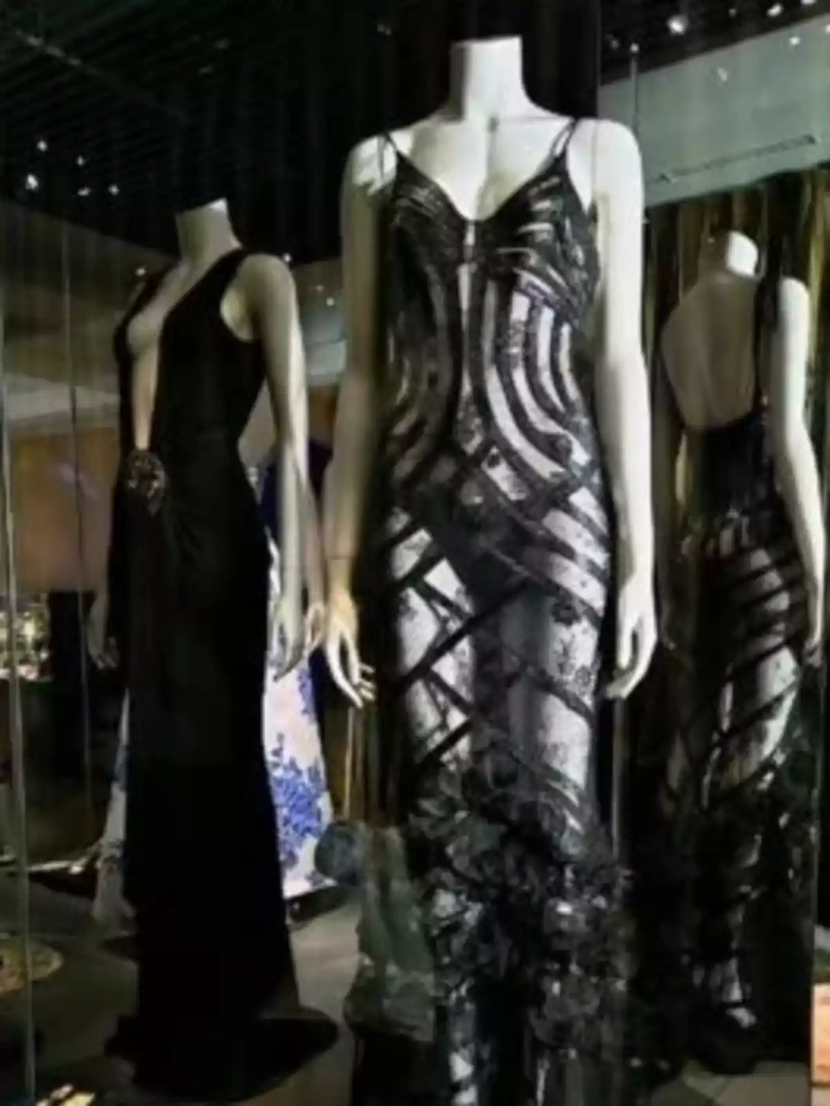 Maniquíes exhibiendo elegantes vestidos de noche en una vitrina. Maniquíes exhibiendo elegantes vestidos de noche en una vitrina.