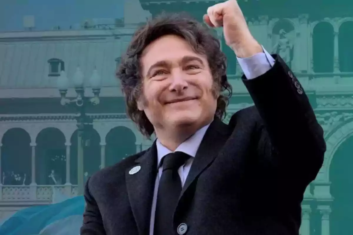 Curly-haired man in a dark jacket raising his fist with a smiling expression in front of a historic building Curly-haired man in a dark jacket raising his fist with a smiling expression in front of a historic building