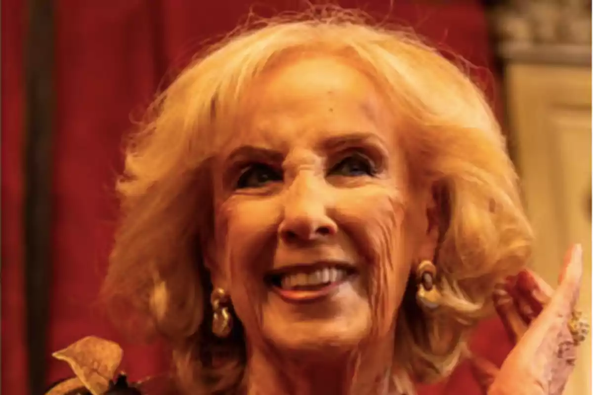 Smiling older blonde woman with a red background