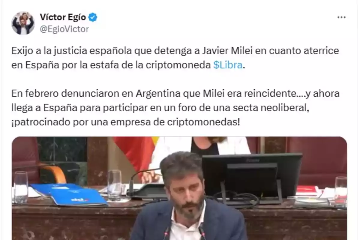 Screenshot of a tweet by Víctor Egío in which he demands that the Spanish justice system arrest Javier Milei for an alleged cryptocurrency-related scam, accompanied by an image of a man speaking in a conference room. Screenshot of a tweet by Víctor Egío in which he demands that the Spanish justice system arrest Javier Milei for an alleged cryptocurrency-related scam, accompanied by an image of a man speaking in a conference room.