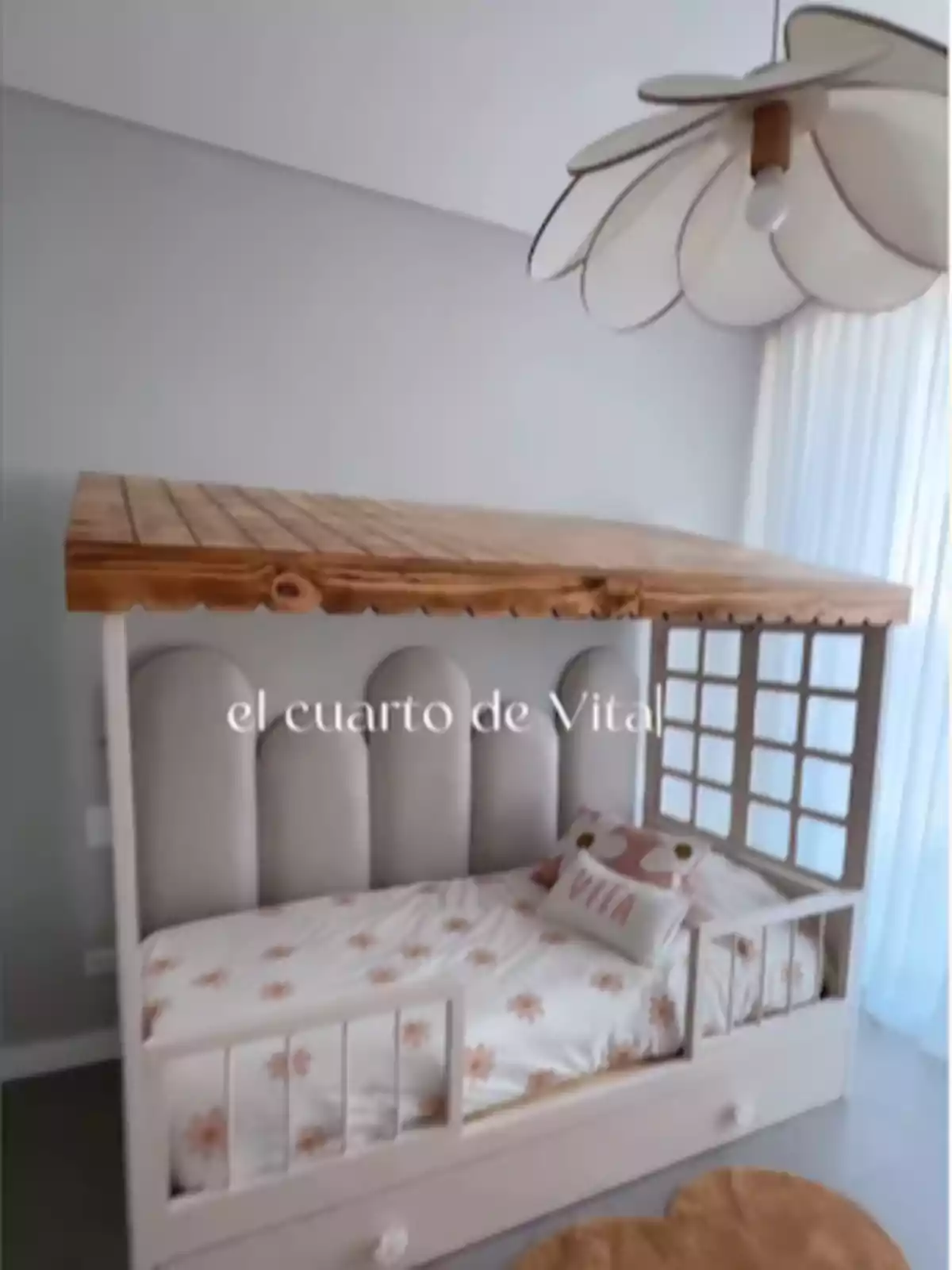 Cama infantil con dosel de madera, ropa de cama con flores, cojines decorativos y lámpara en forma de flor en una habitación luminosa Cama infantil con dosel de madera, ropa de cama con flores, cojines decorativos y lámpara en forma de flor en una habitación luminosa