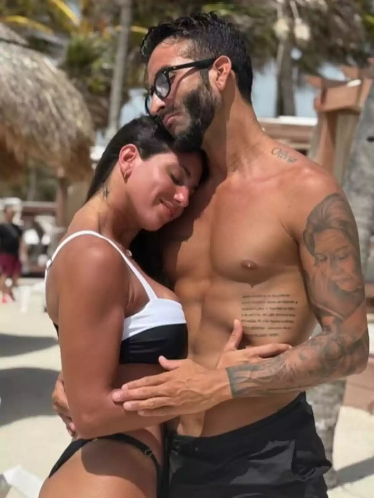 Couple hugging on the beach enjoying a romantic moment under the sun